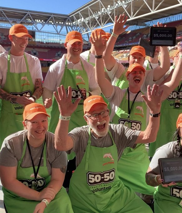 Group of people wearing green aprons and orange hats supporting DESARROLLOS GEDEON III INCby selling 50-50 charity raffle tickets