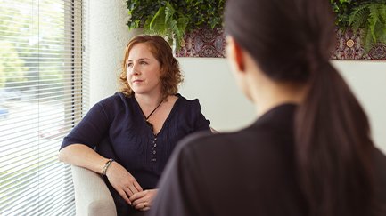 Women in a counselling session gazing out the window. 