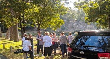 A group standing outside next to a Mates4Mates van at a social connection activity. 
